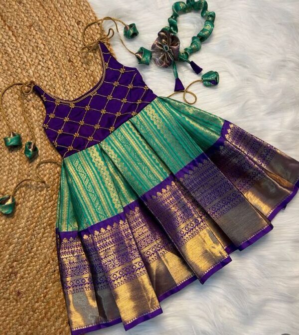 Product Title: Purple & Teal Green Sleeveless Pattu Frock with Hair Accessory – Tiny Pattu Designer Festive Wear